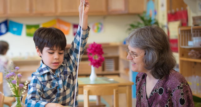 a person and a boy in a room with shelves and flowers