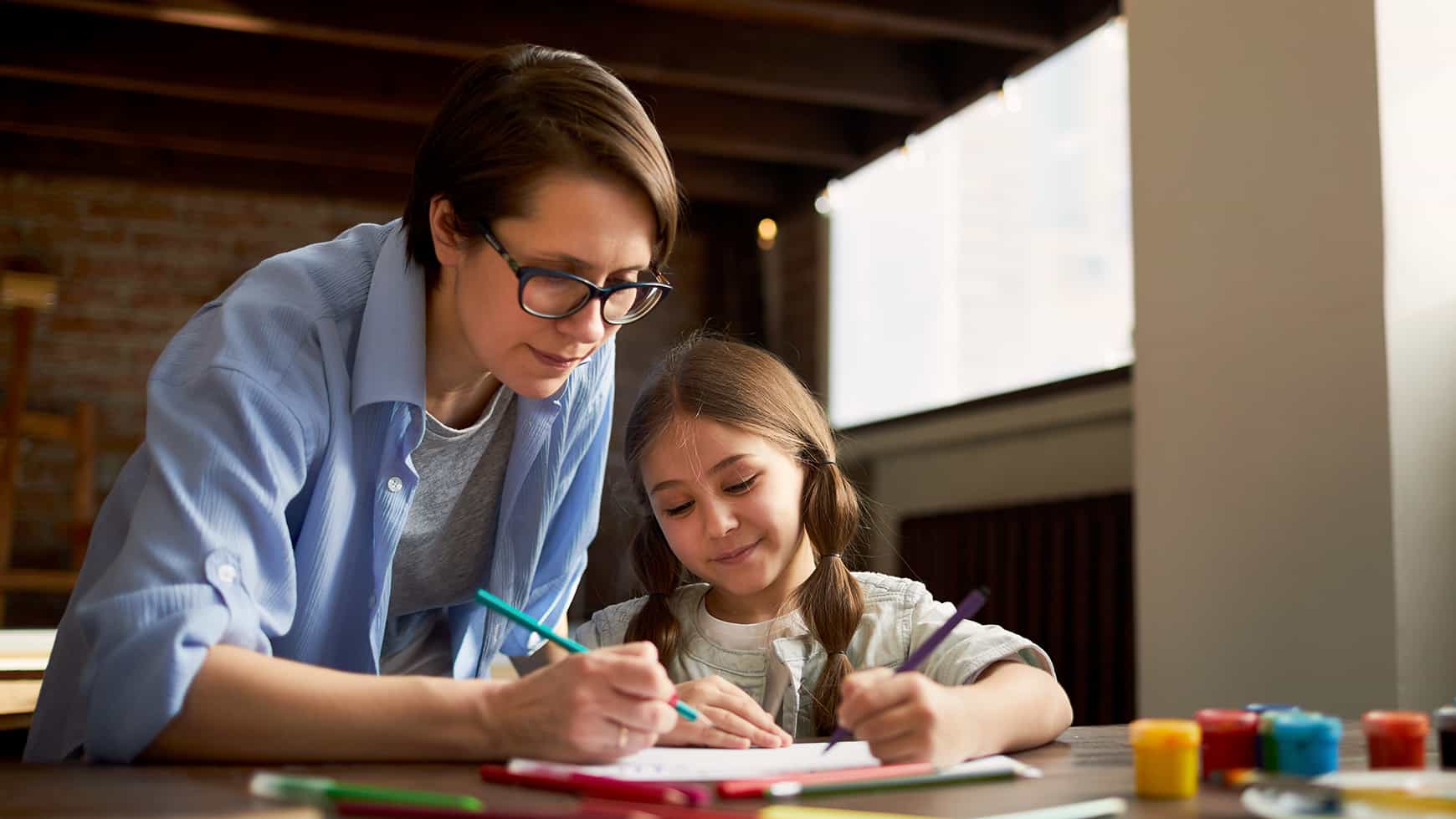 a woman and a girl looking at a paper