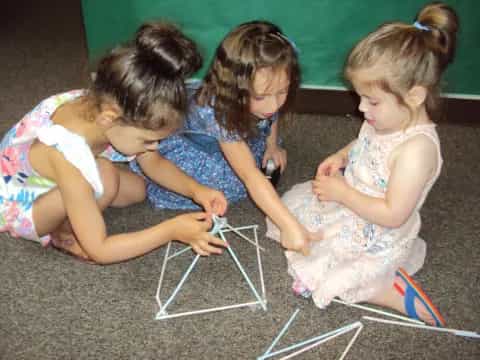 a group of young girls playing with a toy