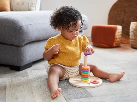 a baby sitting on a rug