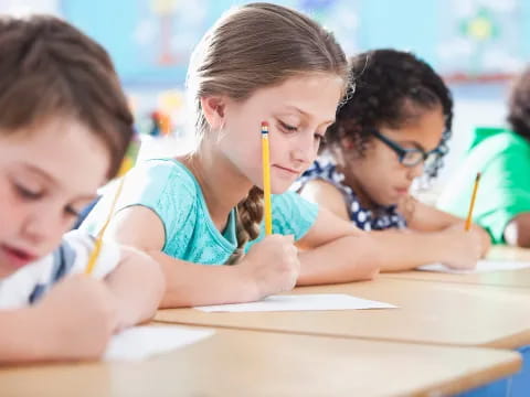 a group of children writing on paper