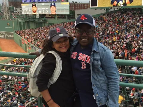 a man and woman posing for a picture in a baseball stadium