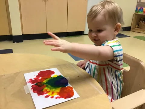 a baby pointing at a pizza