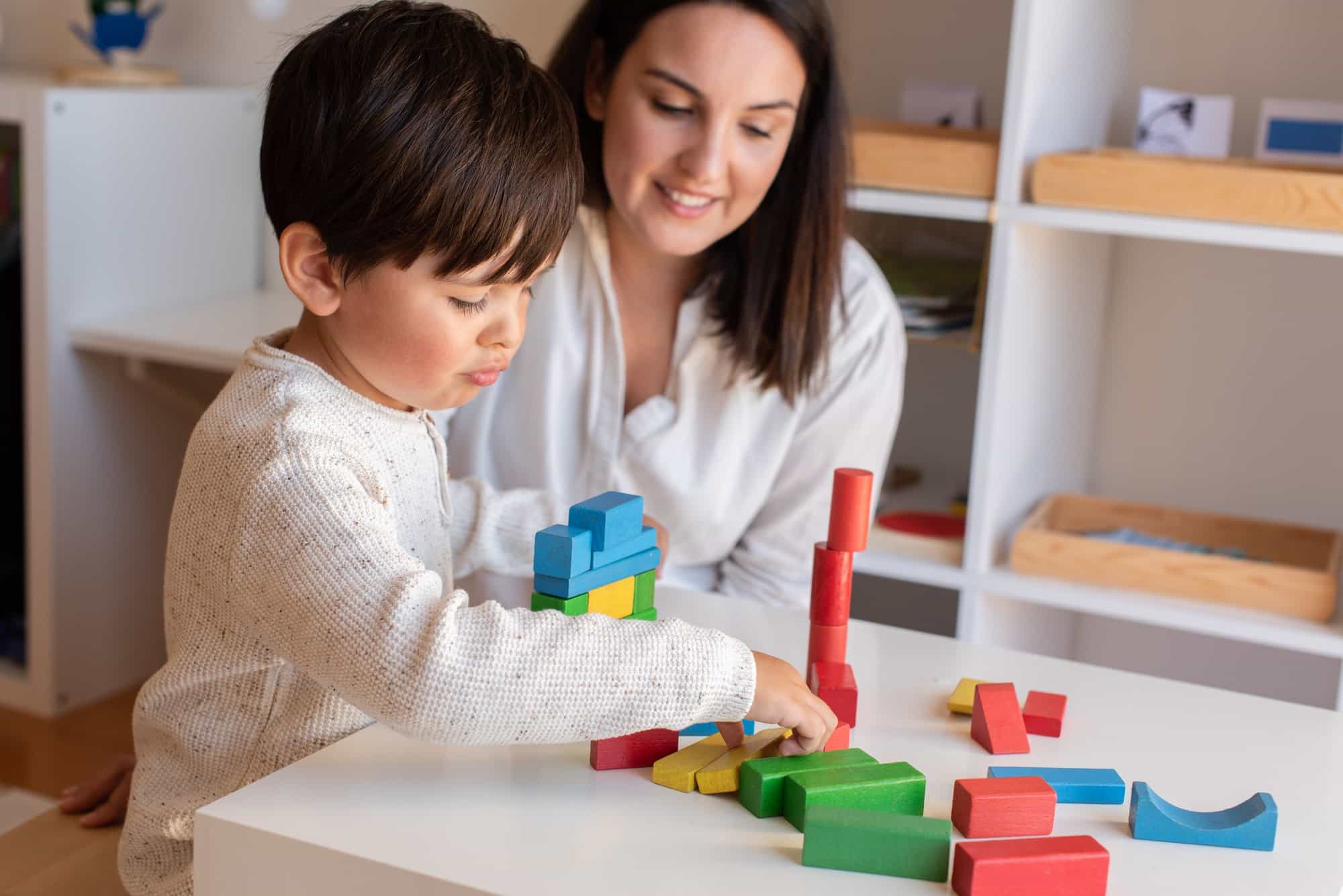 a person and a child playing with building blocks