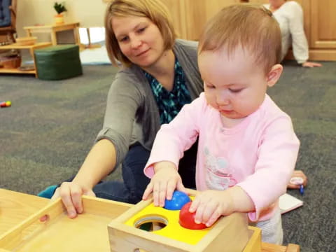 a person and a child playing with toys on a table