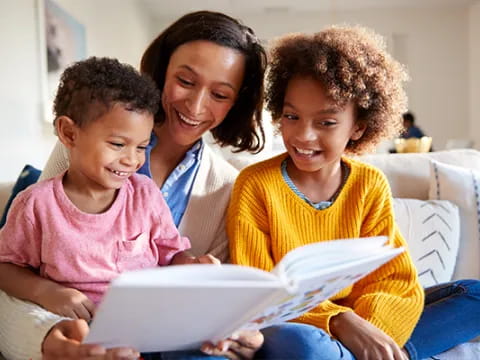 a person and two children looking at a laptop