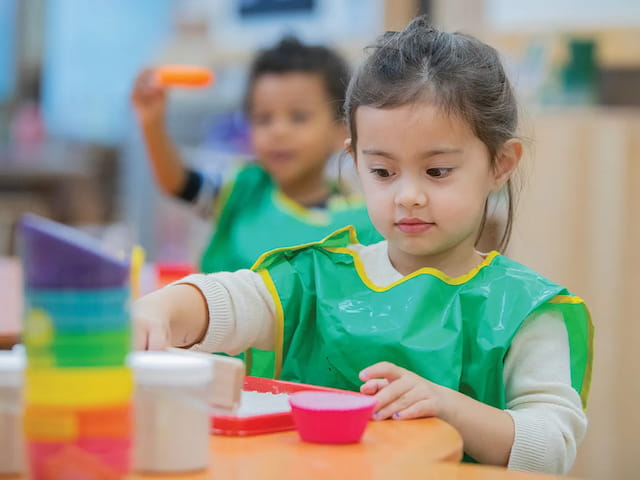 a young girl sitting at a table