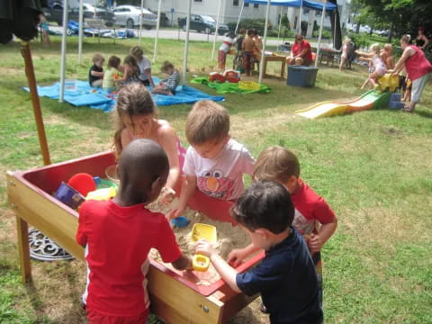 a group of children sitting at a picnic table