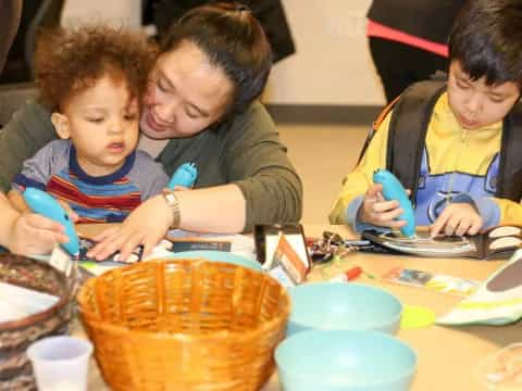 a person and two children playing a board game