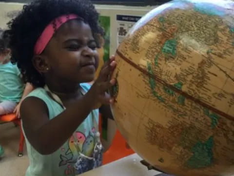 a young girl holding a globe