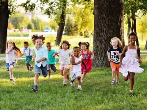 a group of children running in a park