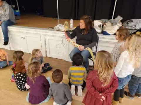 a person playing guitar to a group of children