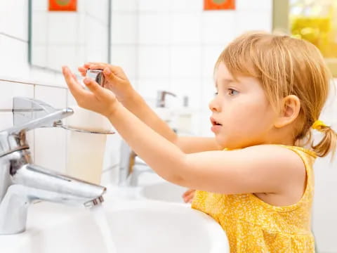 a young girl in a yellow dress takes a picture of herself in the bathroom mirror