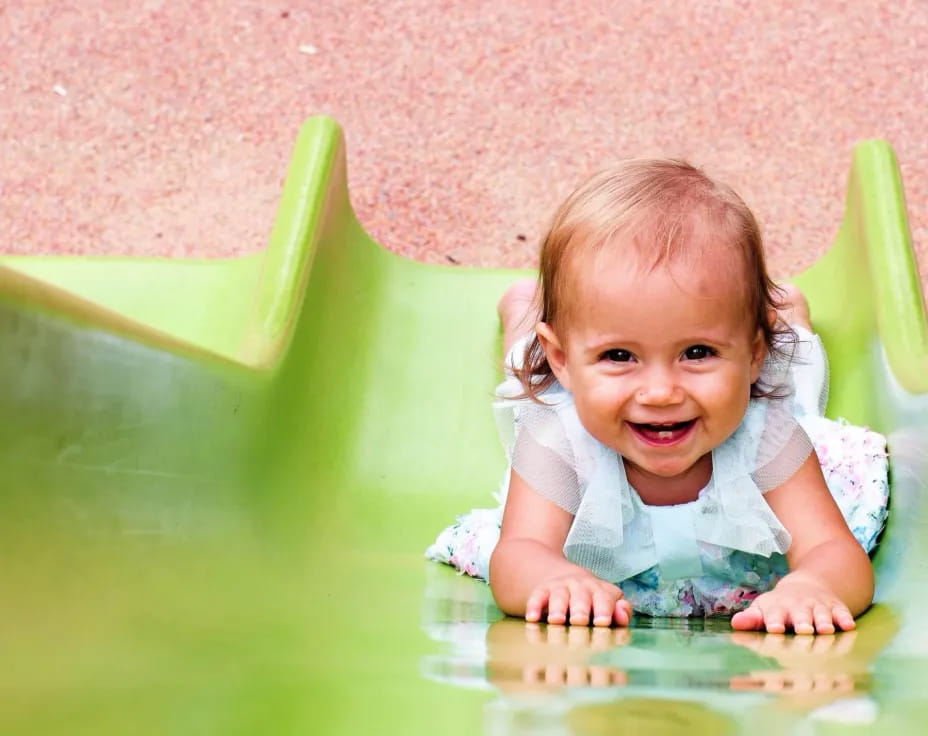 a baby crawling on a green surface