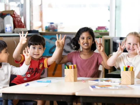 a group of children raising their hands