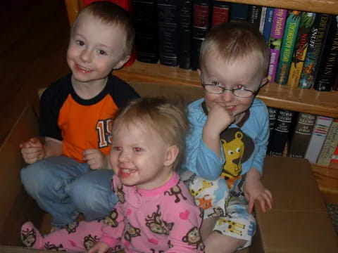 a group of children sitting on the floor in front of a book shelf