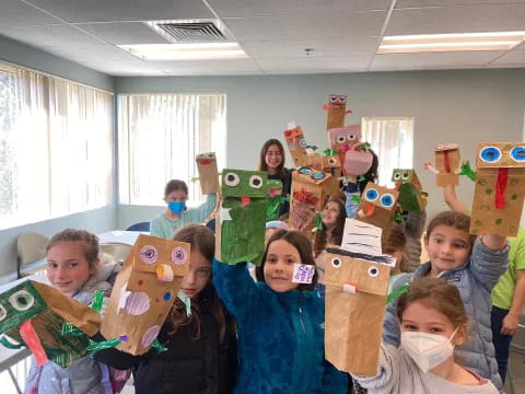 a group of children holding cardboard boxes