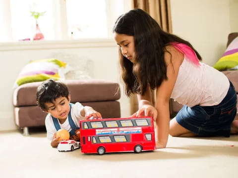 a person and a child playing with a toy truck