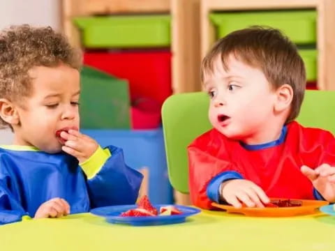 two boys eating at a table