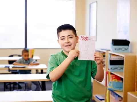 a boy holding a paper