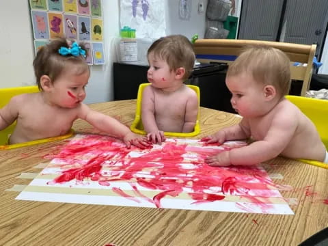 a group of children sitting at a table with a drawing on it
