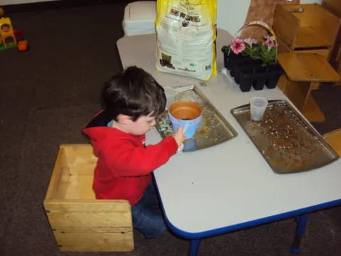 a child sitting at a table with food and drinks