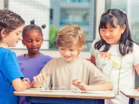 a group of children looking at a tablet