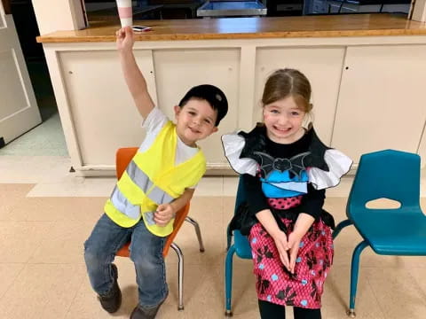 a boy and girl sitting in chairs