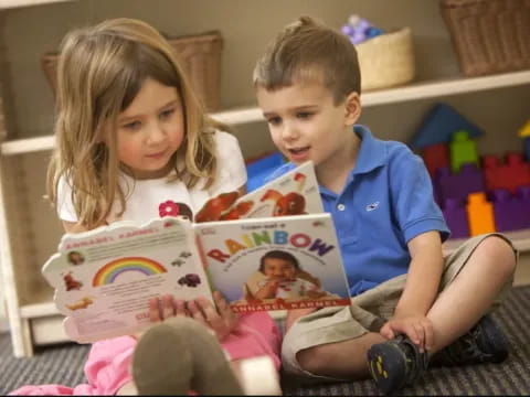 a couple of children reading a book