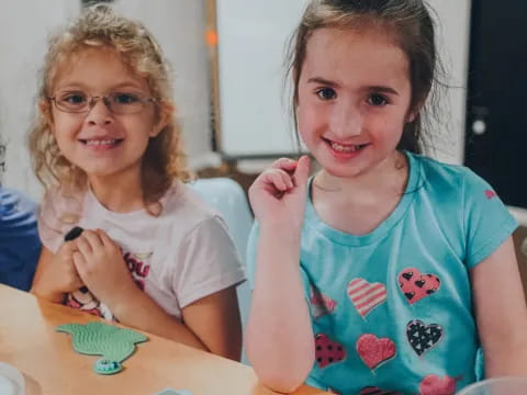 a couple of girls sitting at a table