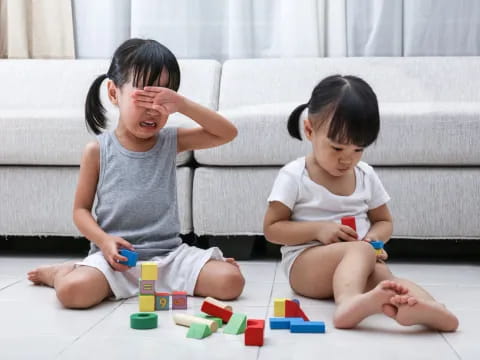 a person and a child playing with toys on the floor