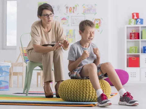 a person and a boy sitting on a chair