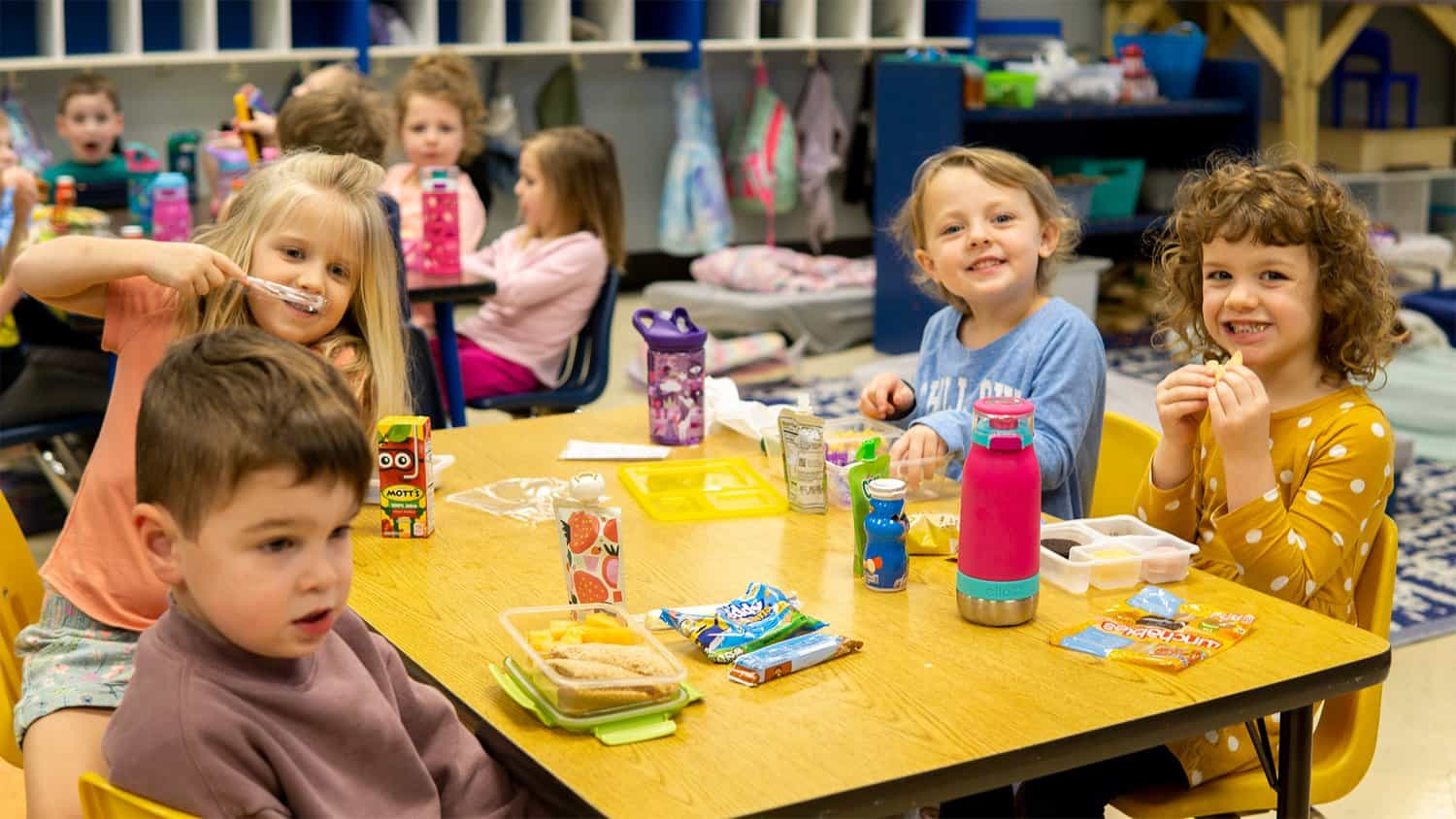 a group of children eating at a table