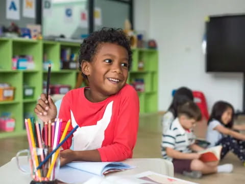 a young boy holding a marker pen