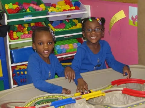 a couple of young girls in a playroom