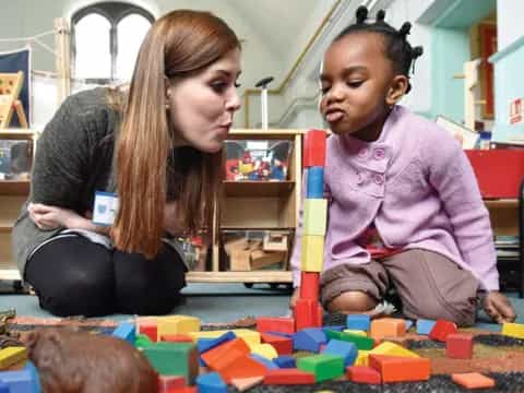 a woman and a child playing with blocks