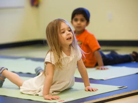 a young girl and boy sitting on the floor