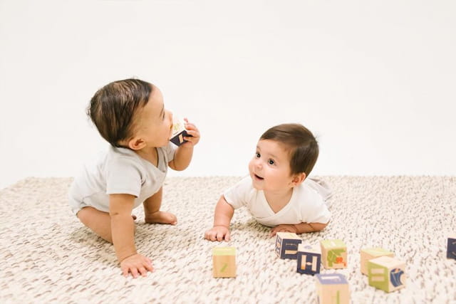 two babies playing with blocks