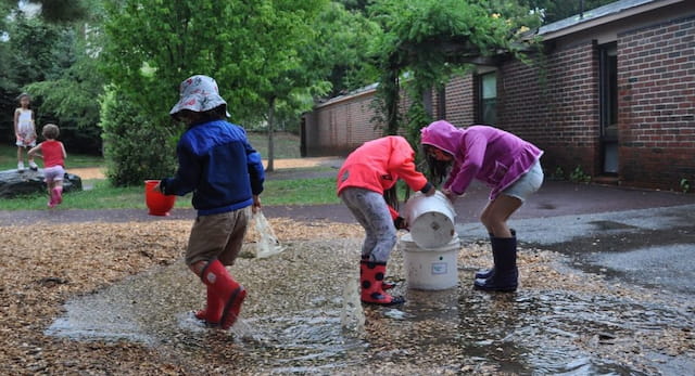 a group of kids playing in a puddle
