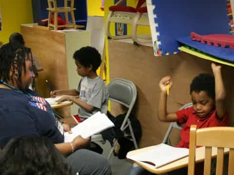 a group of people sitting at desks in a classroom