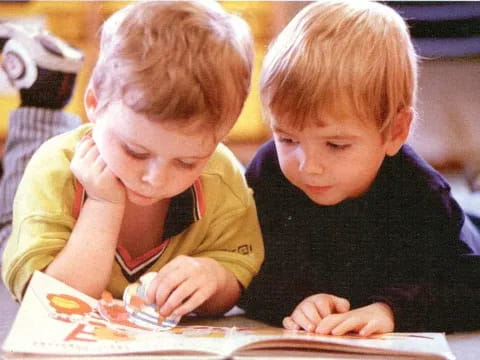 a couple of boys looking at a book