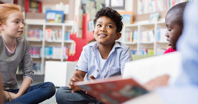 a few children sitting in a library