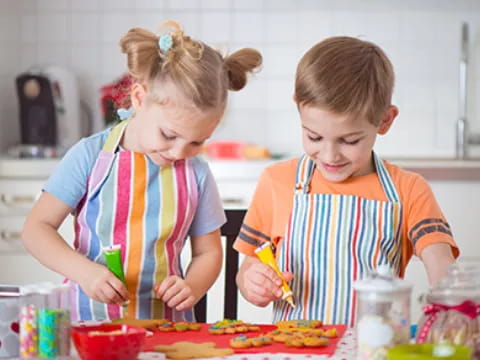 a couple of children making food