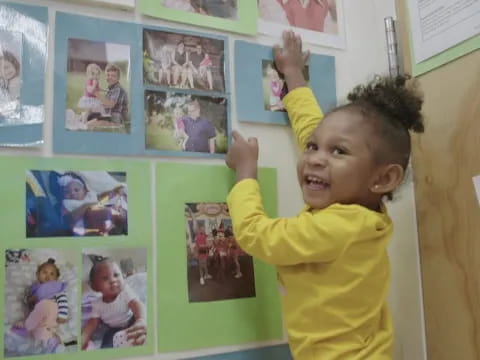 a child with a bunch of pictures on a wall
