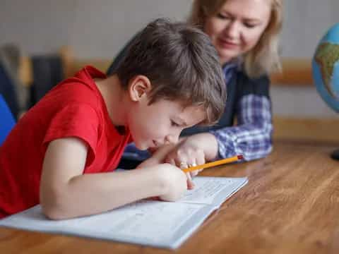 a boy writing on a piece of paper