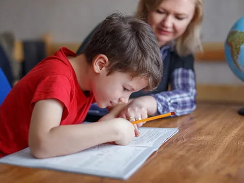 a boy writing on a piece of paper