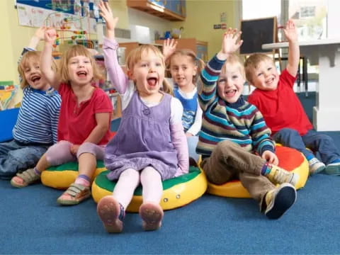 a group of children sitting on a yellow and green mat