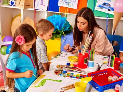 a person and two children painting