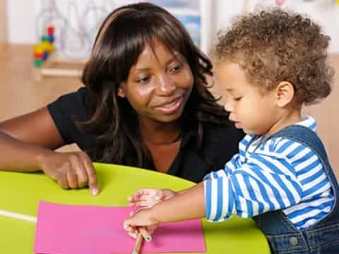 a person and a child looking at a paper