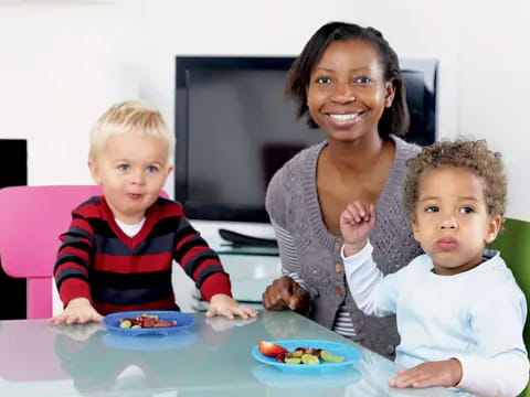 a person and two children sitting at a table